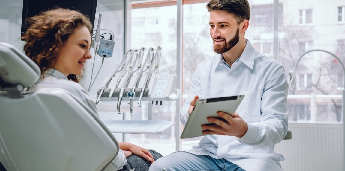 Dentist and patient reviewing dental treatment plan on tablet computer