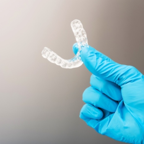Dentist holding occlusal appliance for T M J therapy